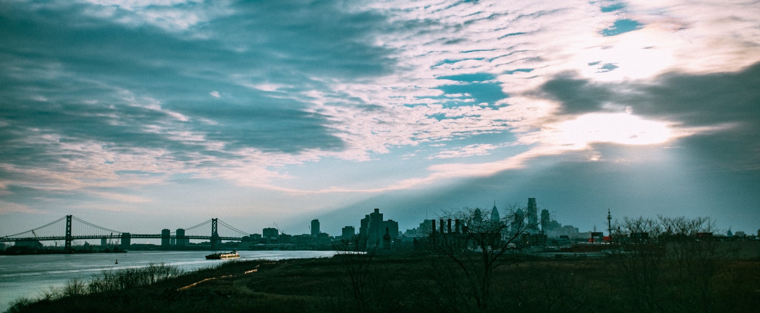 city skyline under white clouds and blue sky during daytime